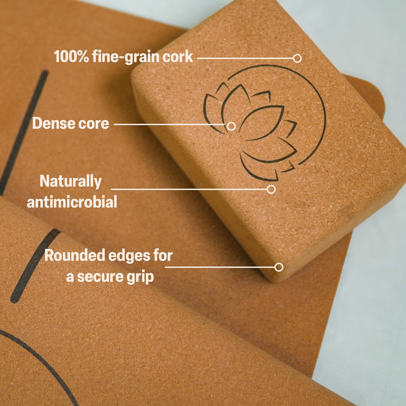A cork yoga block labelled: 100% fine-grain cork, dense core, naturally antimicrobial, rounded edges for a secure grip.